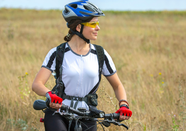 A person riding a bicycle with safety helmet, aimed at preventing spinal cord injuries 